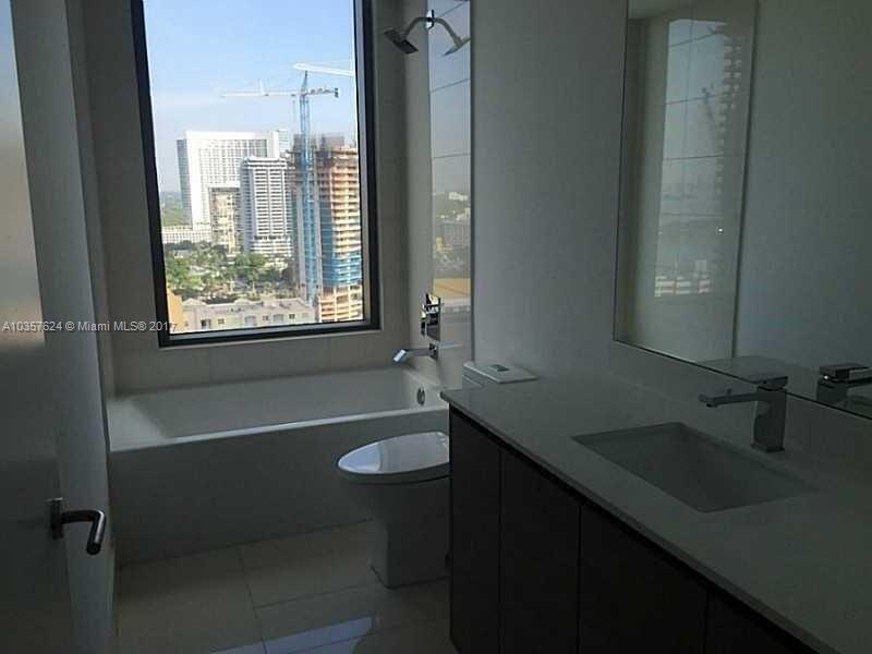 460 Northeast 28th Street, Unit 2001 Miami, FL 33137 - Photo 10 of 28 a bathroom with a granite countertop sink a toilet a shower and a mirror