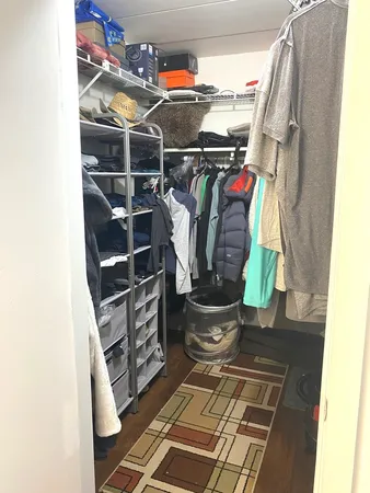 a view of walk in closet with clothes and shoes