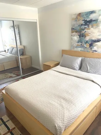 a large bed sitting in a bedroom next to a window