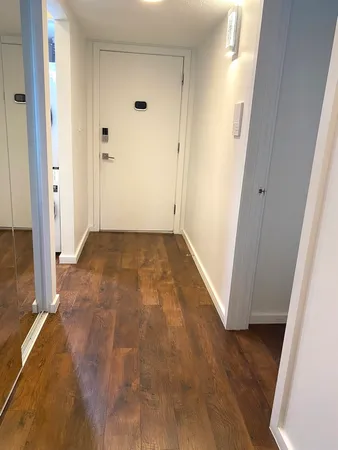 an empty room with wooden floor and entrance
