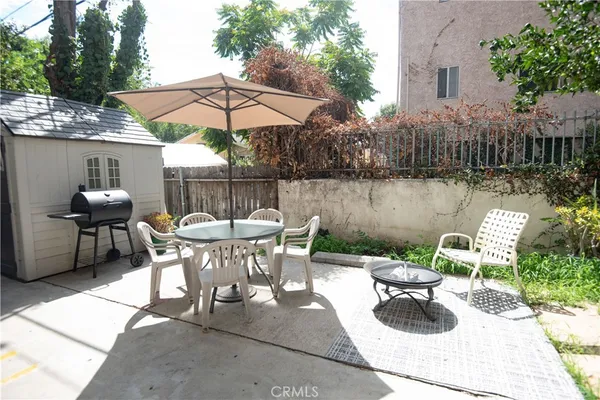 a view of a patio with furniture and a table and chairs under an umbrella