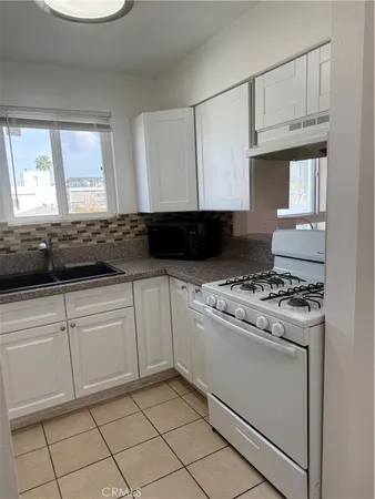 a kitchen with granite countertop white cabinets and white appliances