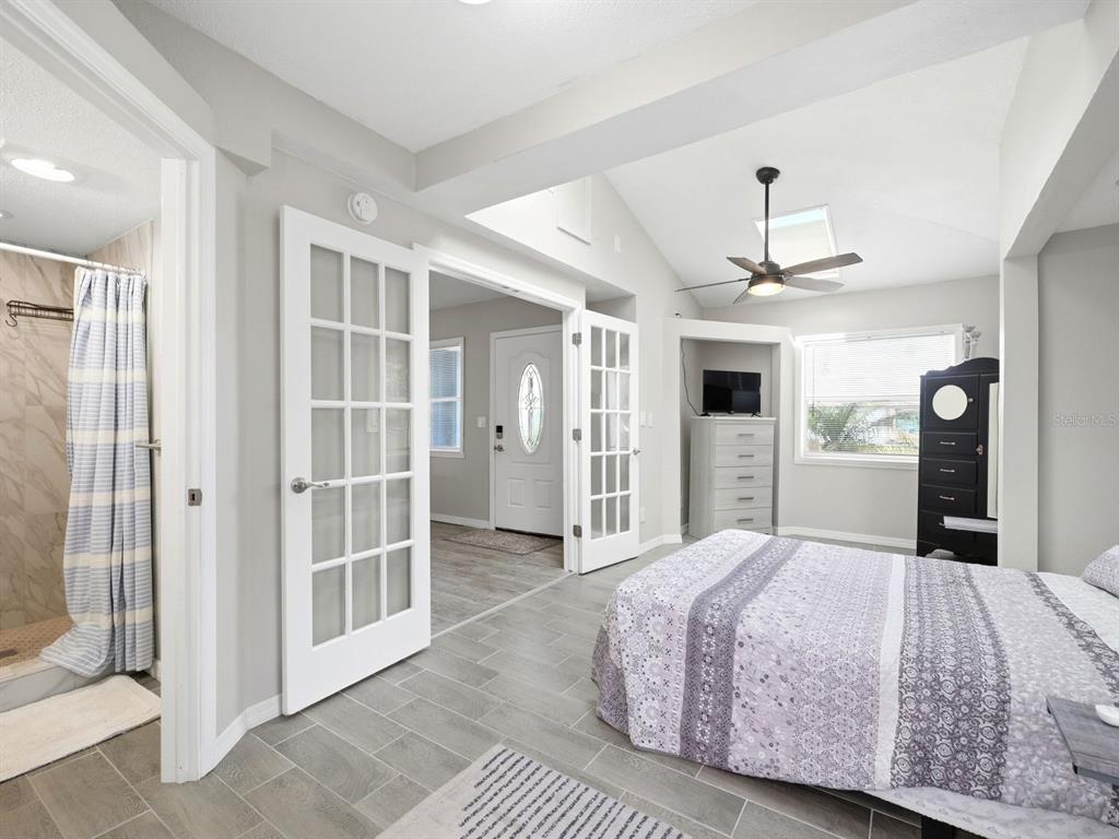 1207 1st Street Indian Rocks Beach, FL 33785 - Photo 24 of 60 a spacious bedroom with a large bed and a chandelier