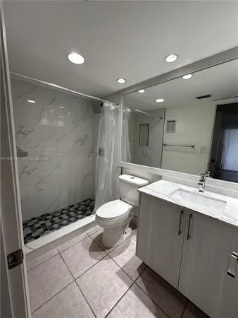 a bathroom with a double vanity sink toilet and shower