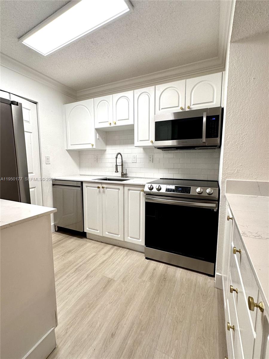 10795 Southwest 108th Avenue, Unit 304 Miami, FL 33176 - Photo 15 of 17 a kitchen with stainless steel appliances granite countertop a stove and a sink