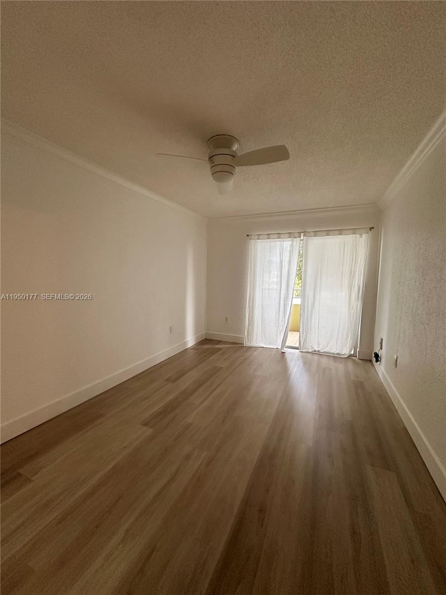 10795 Southwest 108th Avenue, Unit 304 Miami, FL 33176 - Photo 2 of 17 a view of an empty room with wooden floor and window