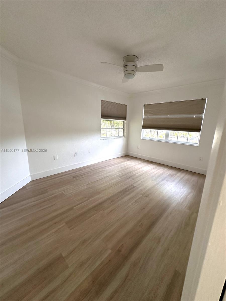 10795 Southwest 108th Avenue, Unit 304 Miami, FL 33176 - Photo 3 of 17 an empty room with wooden floor and windows