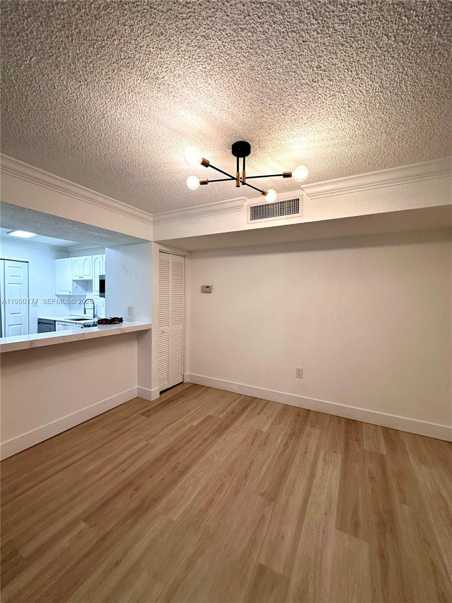 10795 Southwest 108th Avenue, Unit 304 Miami, FL 33176 - Photo 5 of 17 a view of a kitchen with a sink wooden cabinets and a refrigerator