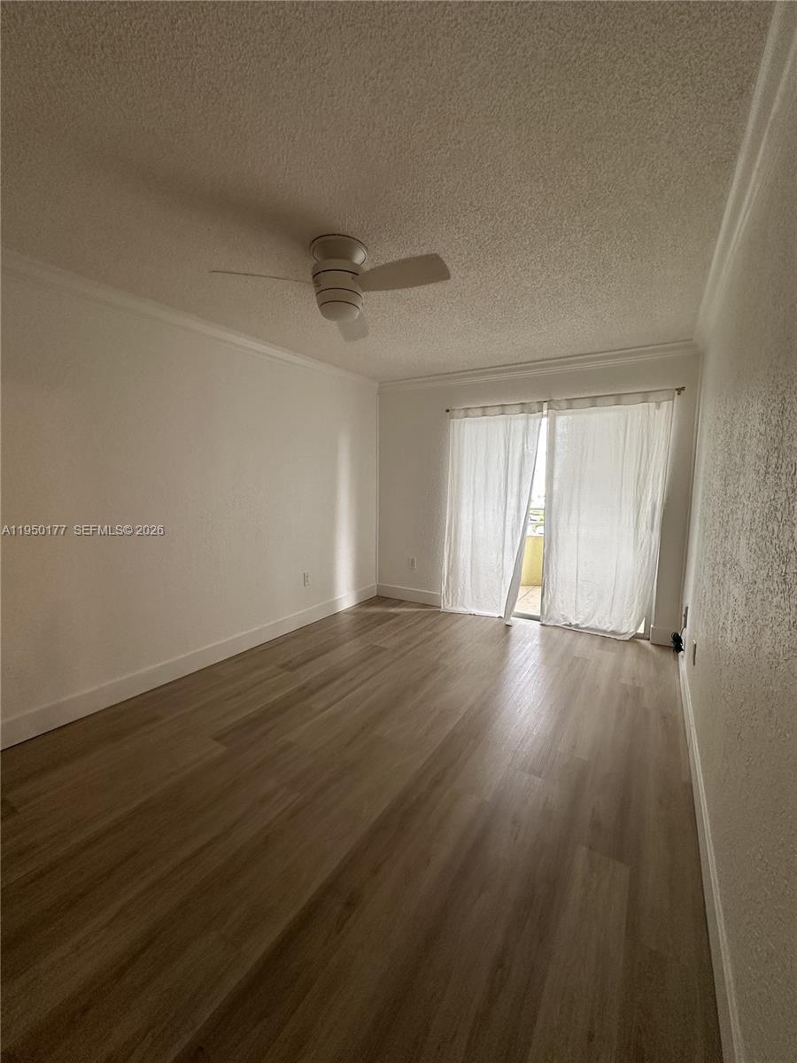 10795 Southwest 108th Avenue, Unit 304 Miami, FL 33176 - Photo 8 of 17 a view of an empty room with wooden floor and window