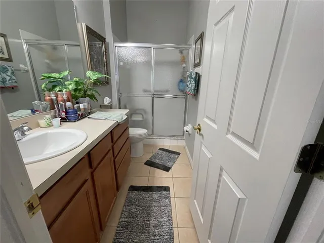 a bathroom with a sink a toilet a mirror and shower