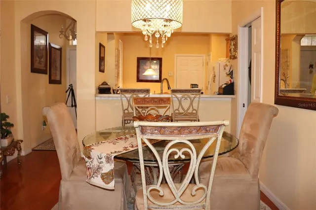 a view of a dining room with furniture a chandelier and wooden floor