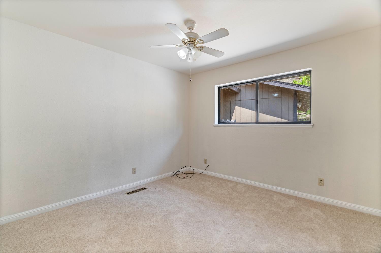 3830 Wilson Loop Placerville, CA 95667 - Photo 11 of 36 an empty room with a chandelier fan and windows