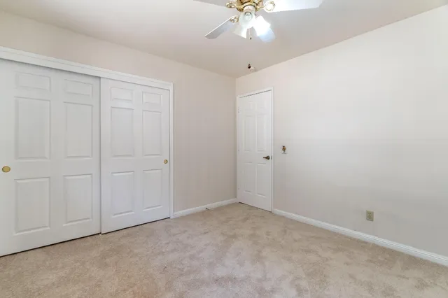 an empty room with a chandelier fan