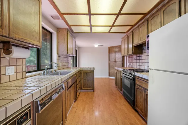 a kitchen with stainless steel appliances granite countertop a stove a sink and a refrigerator