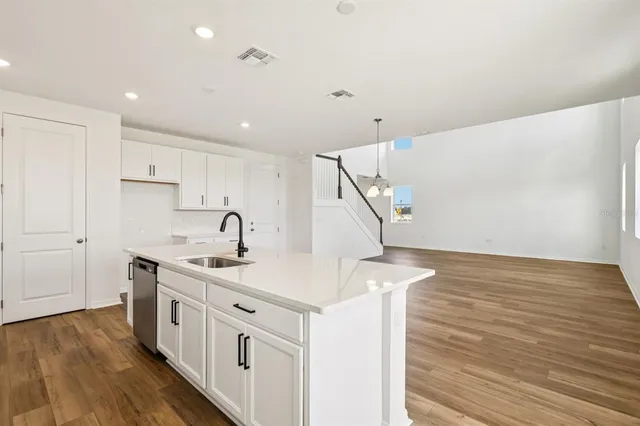 a kitchen with white cabinets appliances and sink