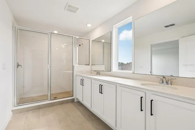 a spacious bathroom with a shower sink and mirror