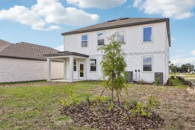 a front view of house with yard and trees around