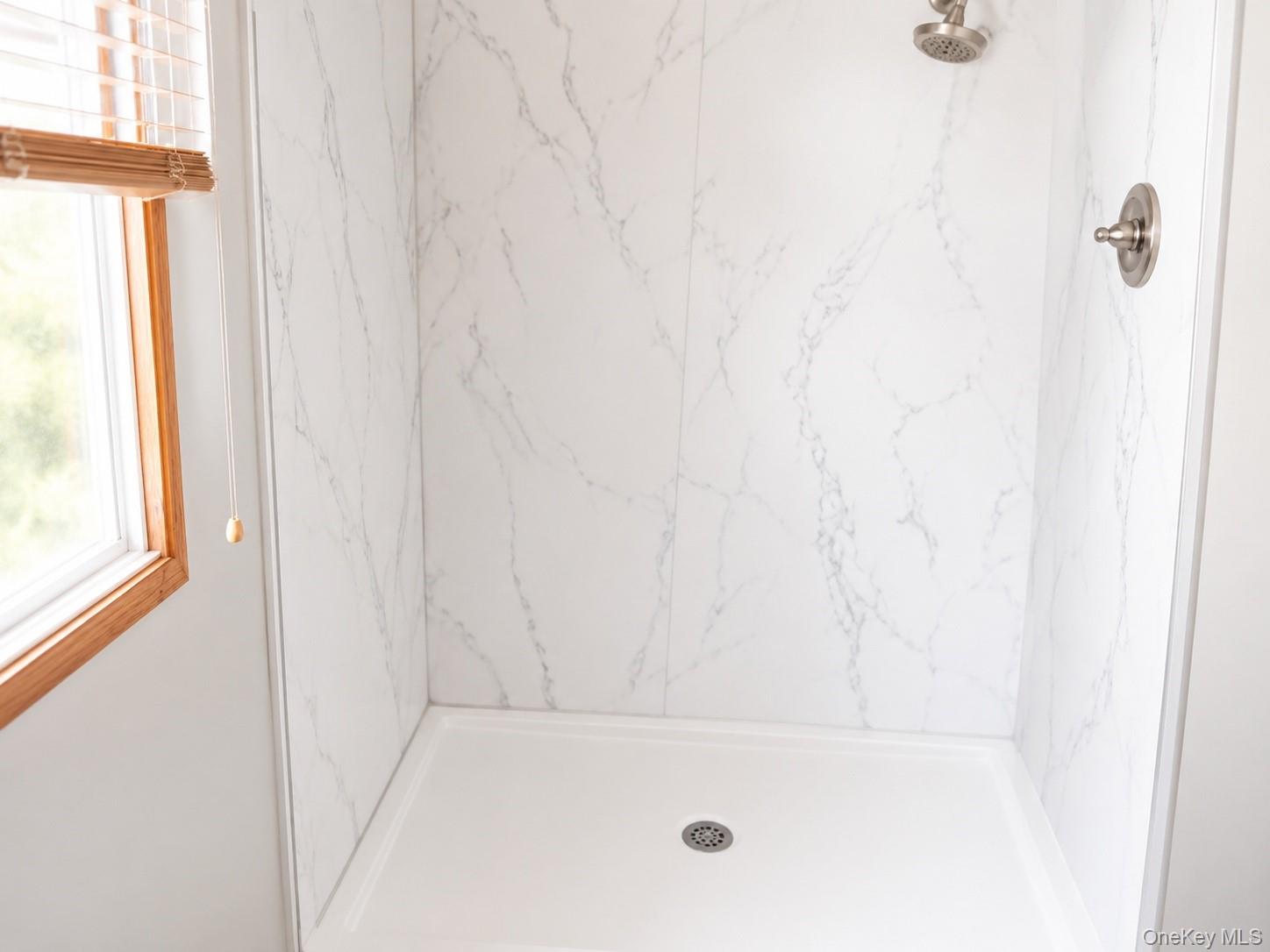 182-184 Mutton Hill Road Neversink, NY 12765 - Photo 12 of 36 Shower stall featuring marble-patterned paneling, a white shower pan, and brushed nickel fixtures
