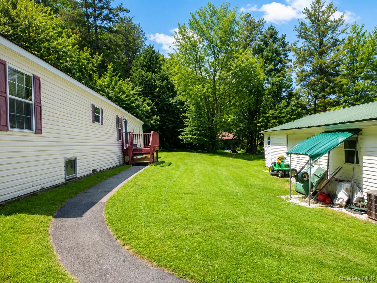 182-184 Mutton Hill Road Neversink, NY 12765 - Photo 19 of 36 Expansive green lawn with a paved pathway leading to a rear deck