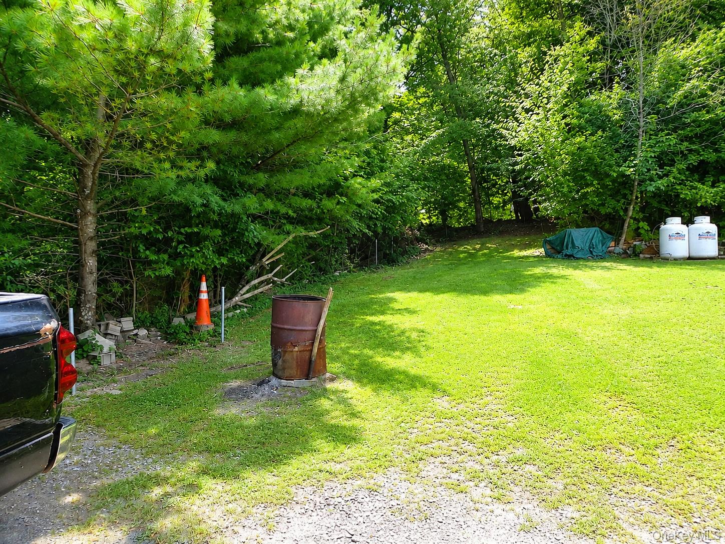 182-184 Mutton Hill Road Neversink, NY 12765 - Photo 35 of 36 Expansive green lawn surrounded by mature trees, featuring a gravel driveway
