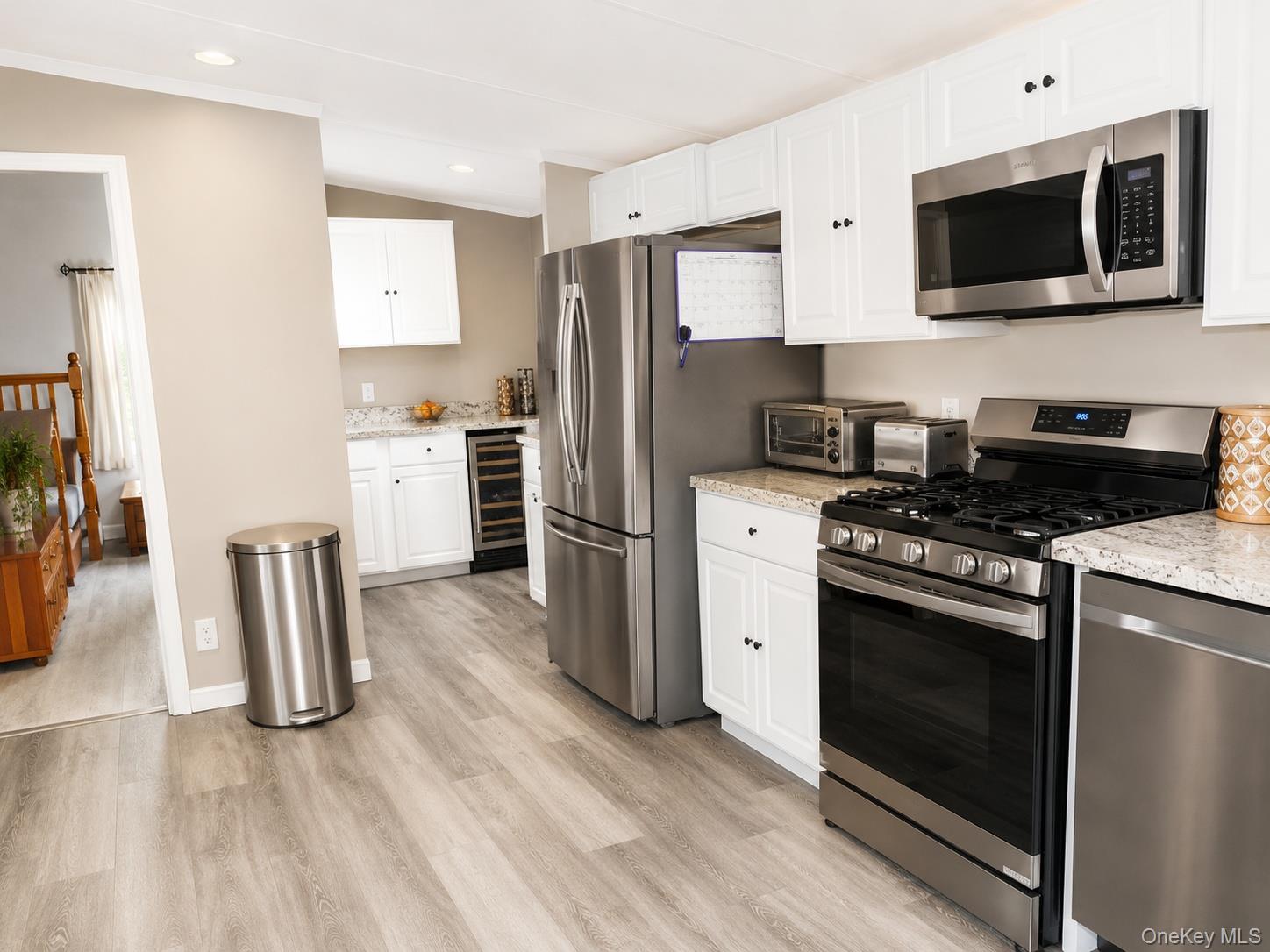 182-184 Mutton Hill Road Neversink, NY 12765 - Photo 6 of 36 Modern kitchen featuring white cabinetry, light-toned countertops, and stainless steel appliances