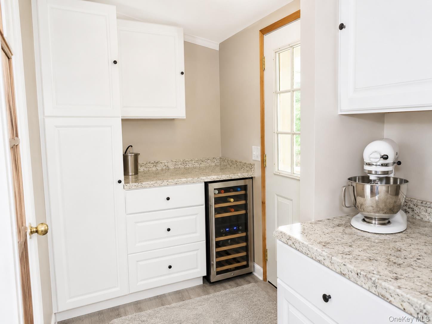 182-184 Mutton Hill Road Neversink, NY 12765 - Photo 7 of 36 Kitchenette featuring white cabinetry with dark hardware, speckled countertops, a built-in beverage cooler, and wood-finish flooring