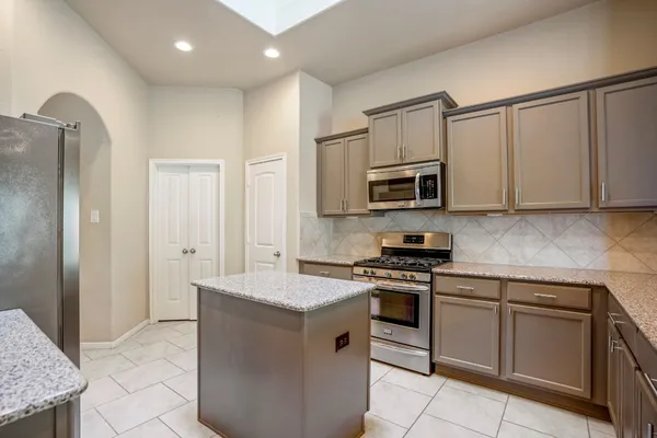 a spacious bathroom with a granite countertop sink a mirror and shower