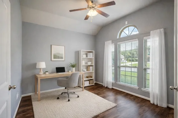 a view of an empty room with wooden floor fireplace and a window