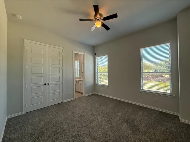an empty room with a window and a fan