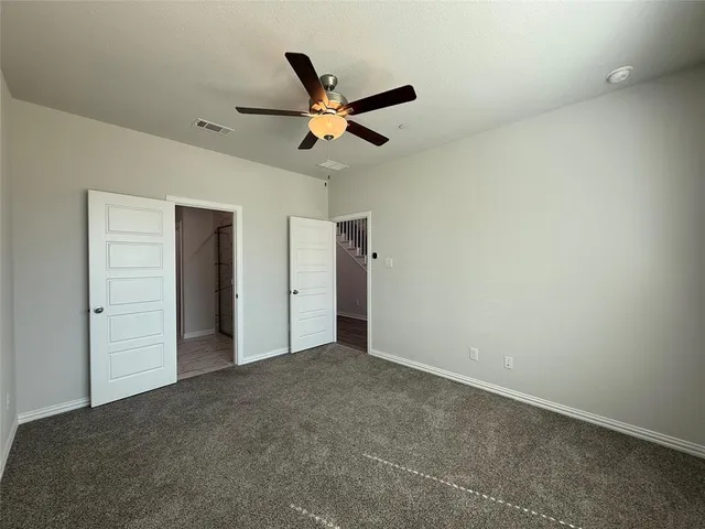 an empty room with windows and fan