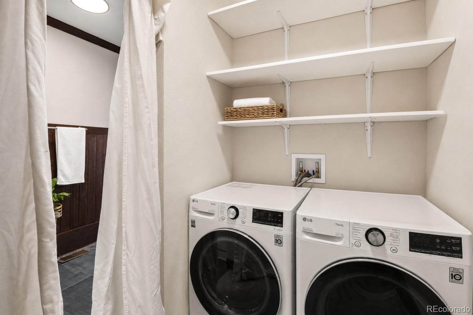 7520 South Blue Creek Road Evergreen, CO 80439 - Photo 16 of 22 a view of washer and dryer with bathroom in the background