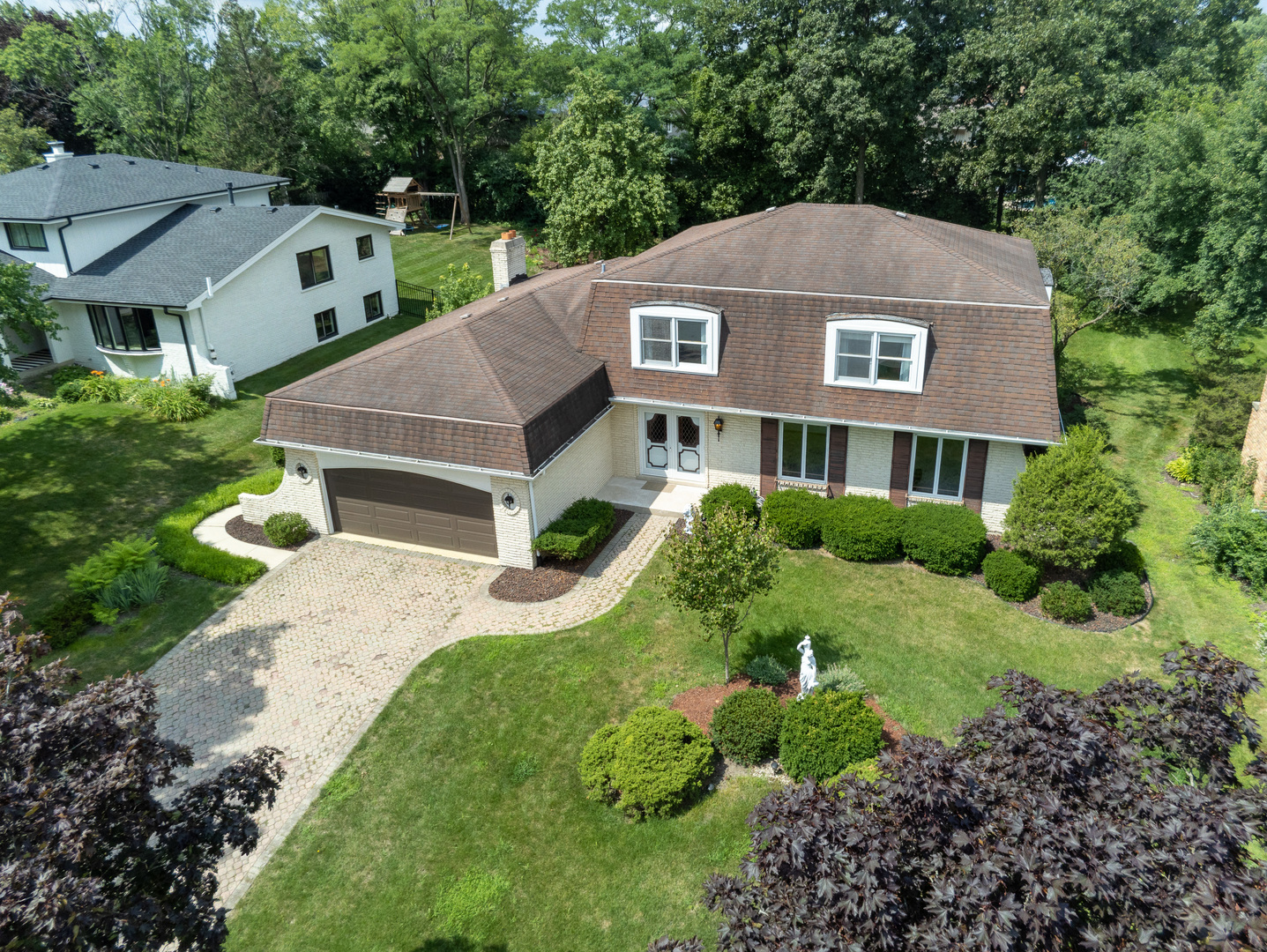 a aerial view of a house next to a big yard and large trees