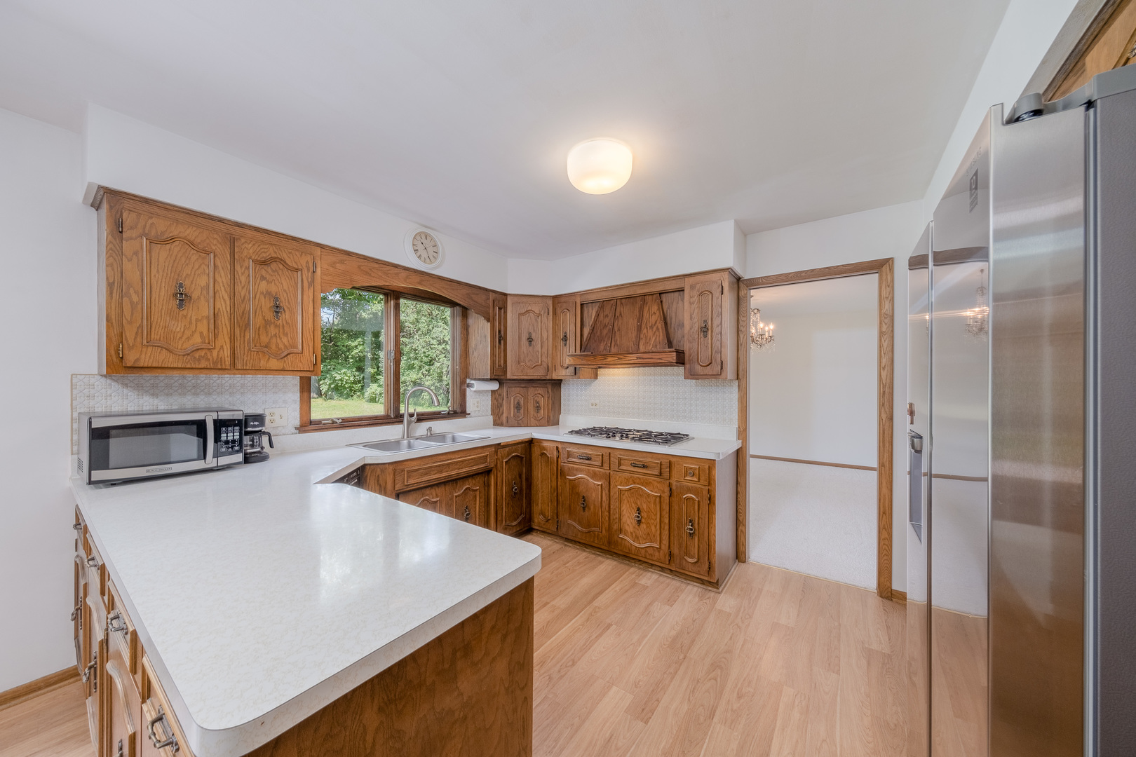 8436 Clynderven Road Burr Ridge, IL 60527 - Photo 15 of 39 a kitchen with stainless steel appliances granite countertop a refrigerator a sink and a stove with wooden floor