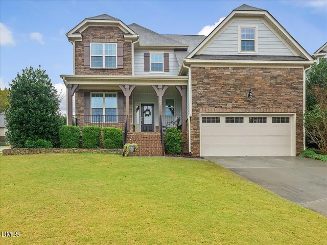 a front view of a house with a yard and garage