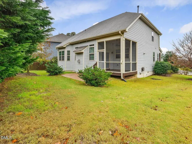 a view of a house with garden space and trees in the background