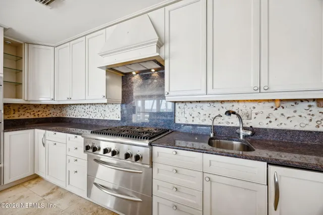 an empty room with windows and chandelier fan