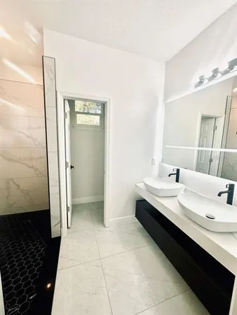 a bathroom with a double vanity sink and mirror
