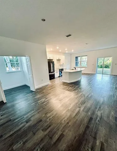 a view of a living room and kitchen with furniture and wooden floor