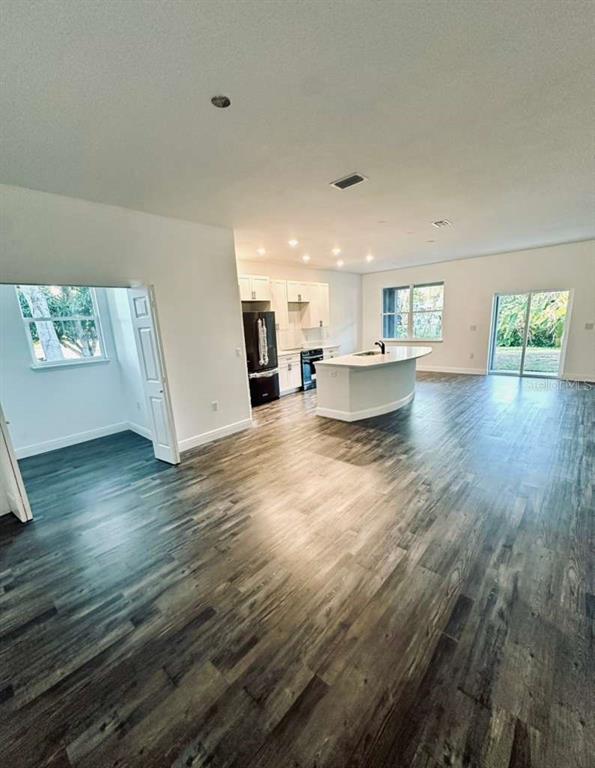 121 Argyle Avenue Frostproof, FL 33843 - Photo 16 of 26 a view of a living room and kitchen with furniture and wooden floor
