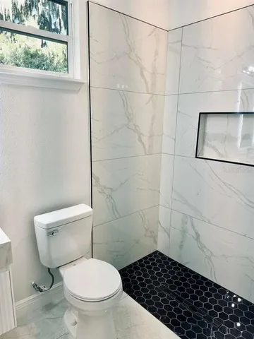 a bathroom with a toilet and a shower