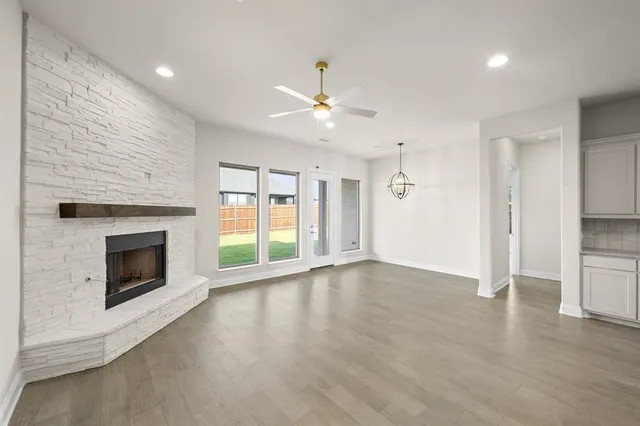 a view of an empty room with a fireplace and a window