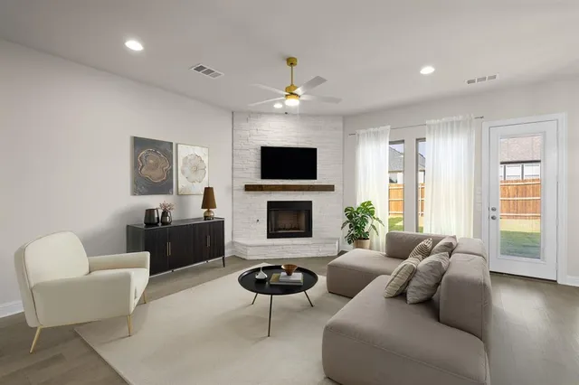 a living room with furniture a flat screen tv and a fireplace