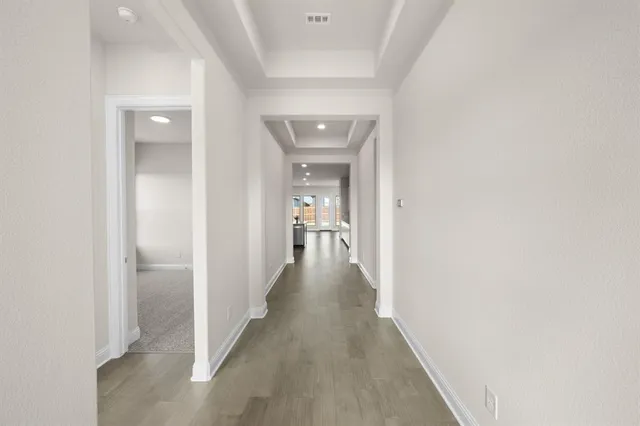 a view of a hallway with wooden floor