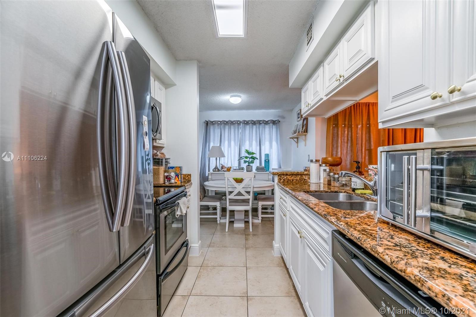 a kitchen with stainless steel appliances granite countertop a refrigerator and a stove