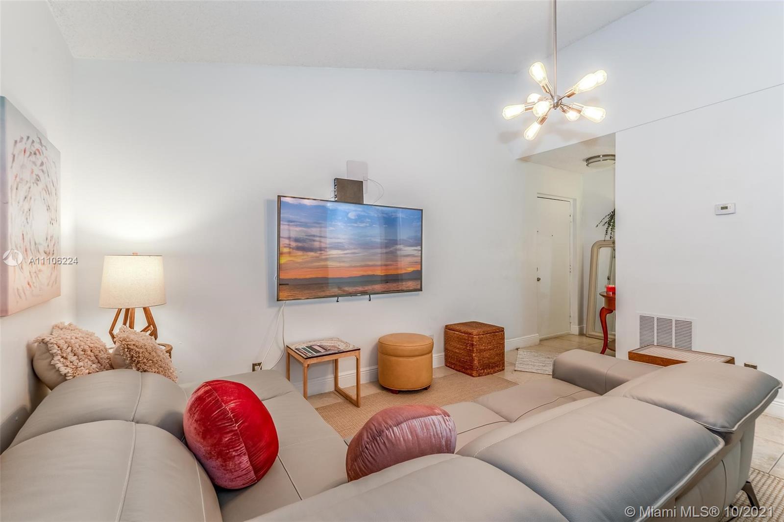 5720 Rock Island Road, Unit 391 Tamarac, FL 33319 - Photo 11 of 27 a living room with furniture a chandelier and a mirror