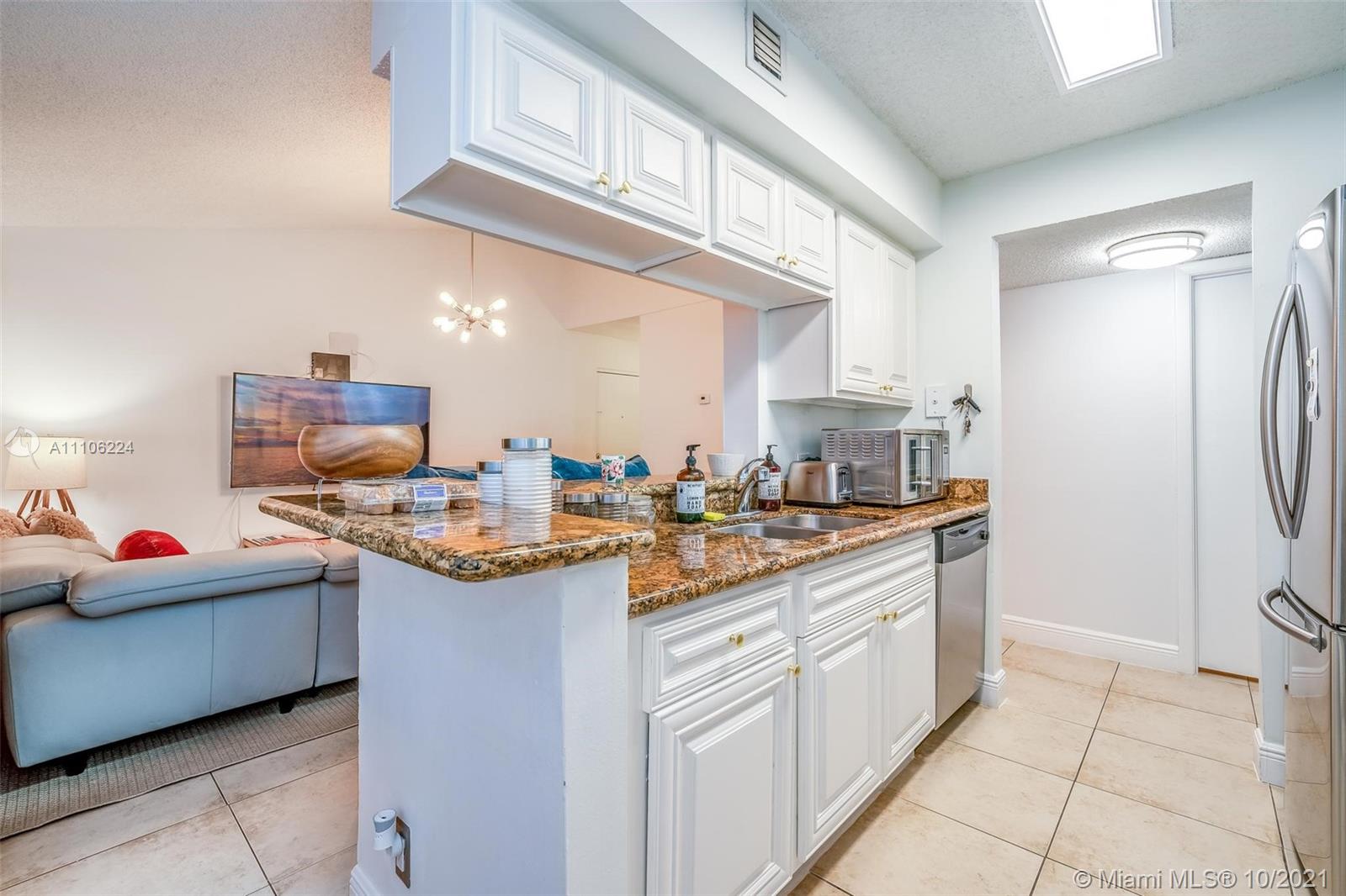 5720 Rock Island Road, Unit 391 Tamarac, FL 33319 - Photo 16 of 27 a kitchen with stainless steel appliances granite countertop a sink and cabinets