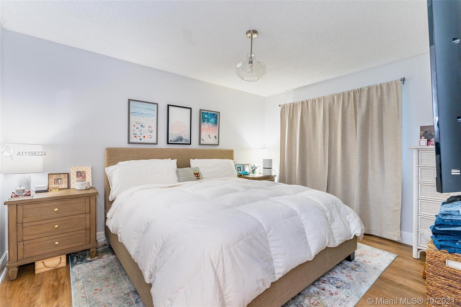 5720 Rock Island Road, Unit 391 Tamarac, FL 33319 - Photo 4 of 27 a bedroom with a bed and a painting on the wall