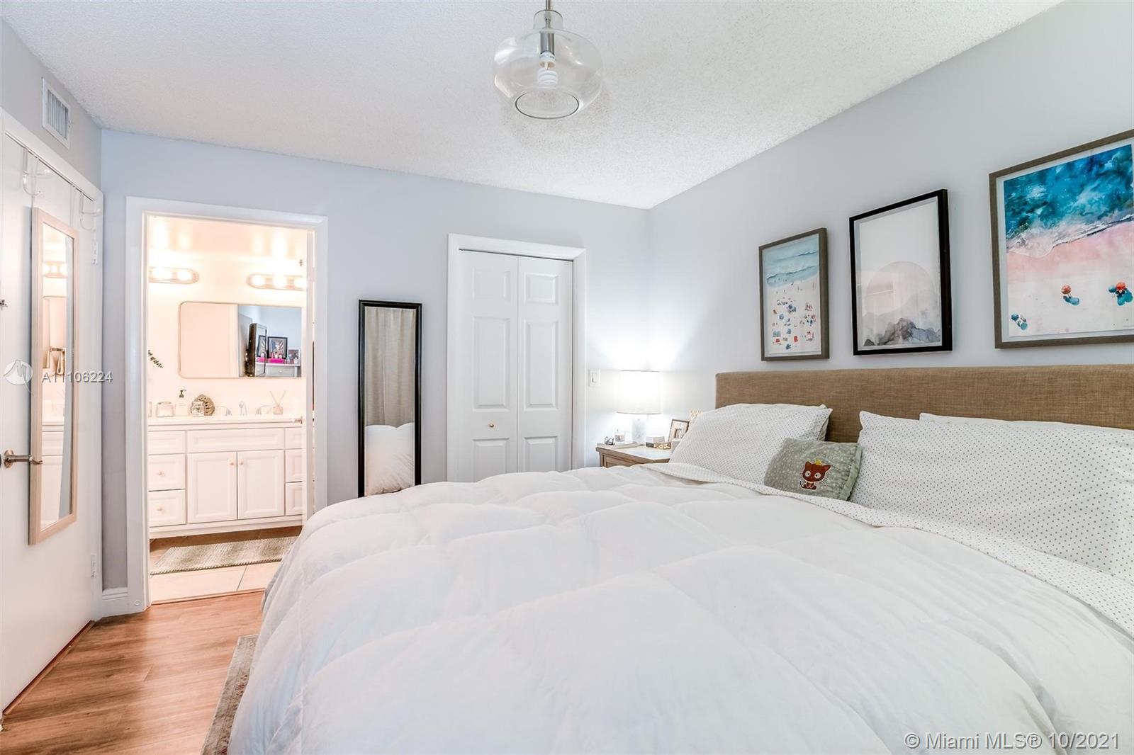 5720 Rock Island Road, Unit 391 Tamarac, FL 33319 - Photo 5 of 27 a bedroom with a large bed and paintings on the wall