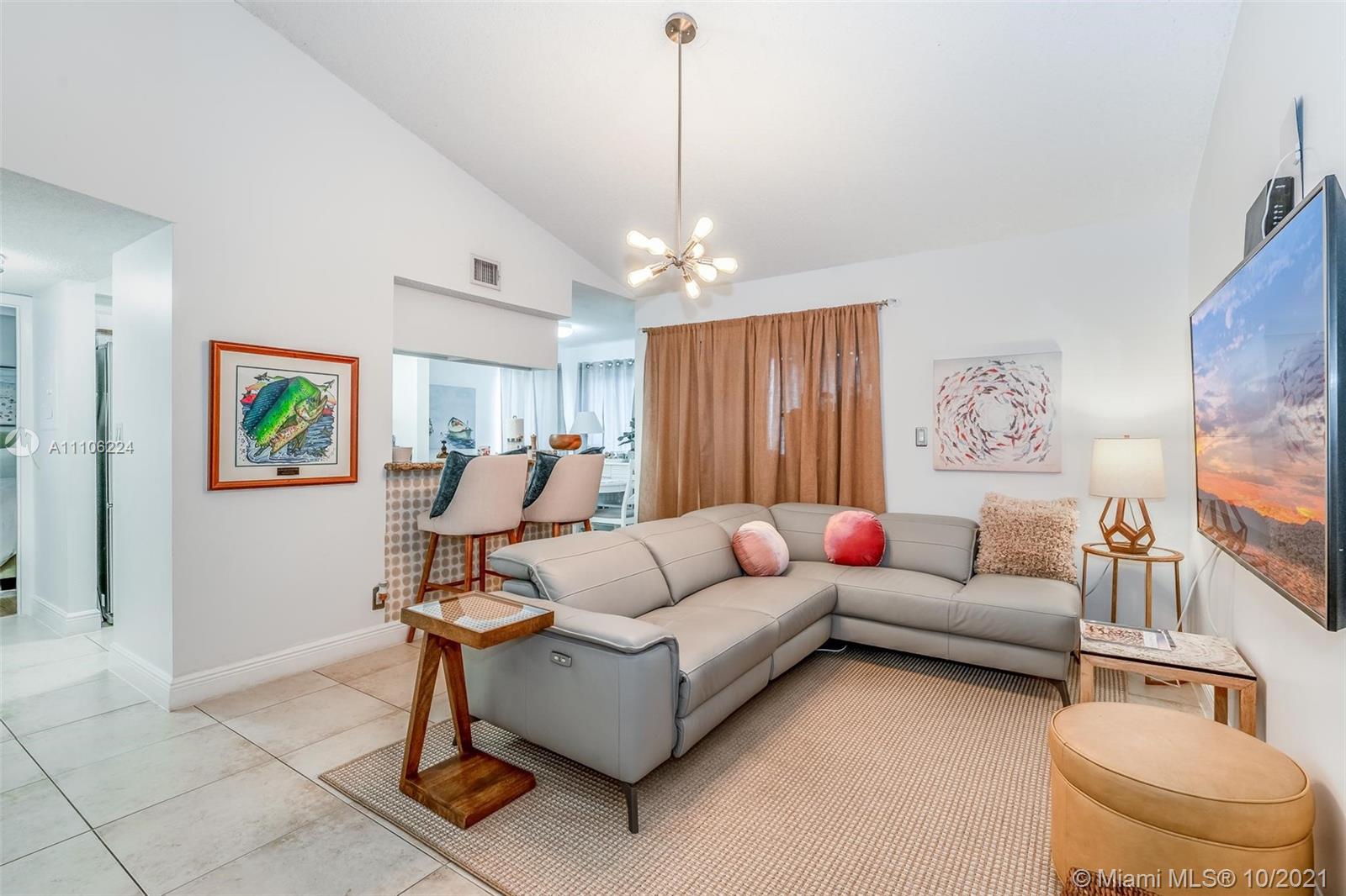5720 Rock Island Road, Unit 391 Tamarac, FL 33319 - Photo 10 of 27 a living room with furniture and a chandelier