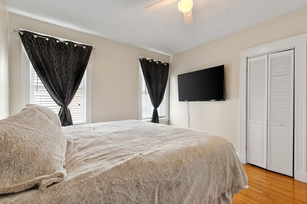 178 Norfolk Avenue, Unit 178 Swampscott, MA 01907 - Photo 21 of 33 a bedroom with a bed a flat screen tv and a chandelier